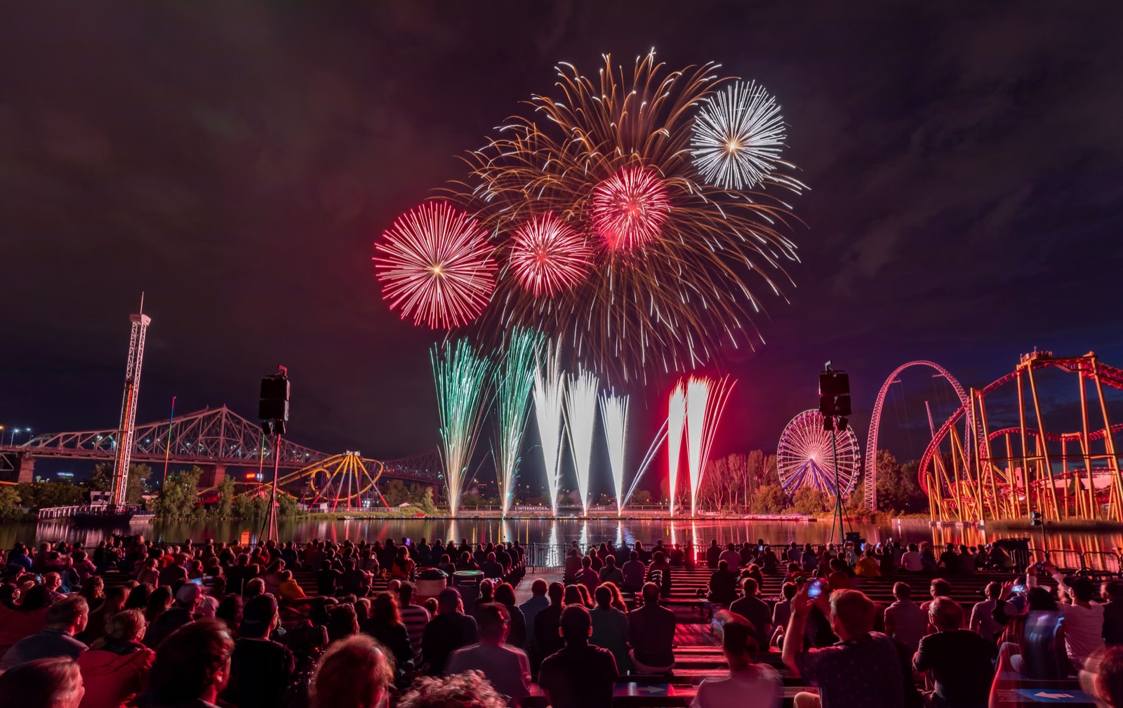 Crowd watching a fireworks show over the water at La Ronde, Montreal
